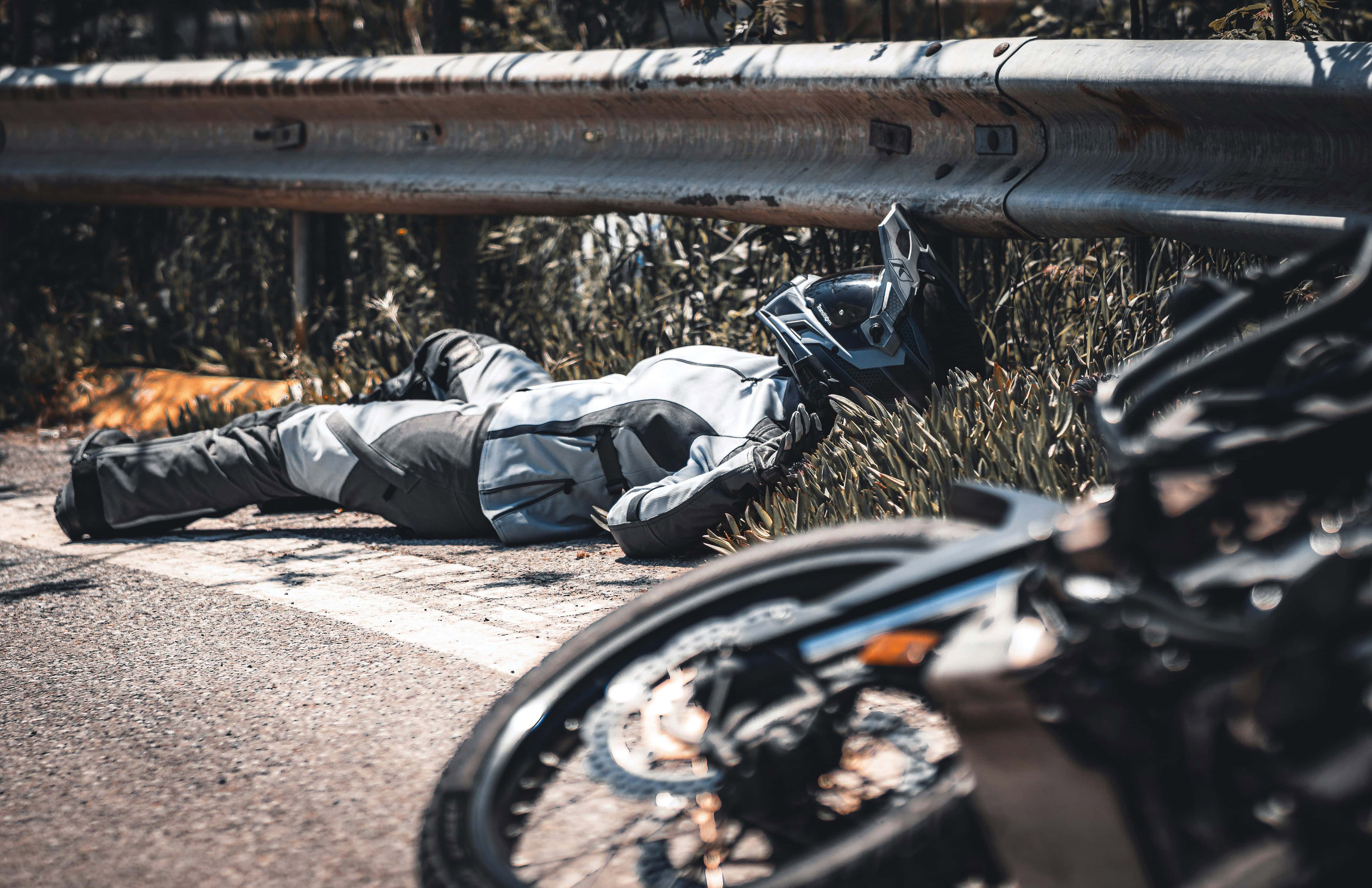 Motorradunfall, Person unter Leitplanke