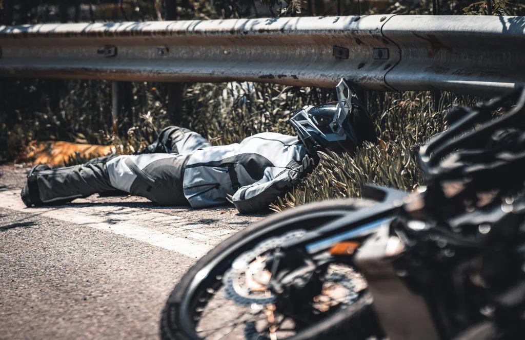 Motorradunfall, Person unter Leitplanke